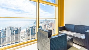 Une chambre située dans un immeuble de grande hauteur, dotée d’une grande fenêtre donnant sur la ville.