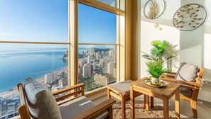 Een hoog appartementencomplex met een groot raam met uitzicht op een stadsgezicht en de zee.