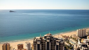 Een hotel aan de kust met meerdere gebouwen, een strand en een helder uitzicht over de oceaan.