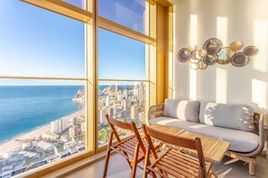 A modern living room with a large window overlooking a cityscape and the sea. - Intempo by Holuxe - 332 - 33th floor (Benidorm)