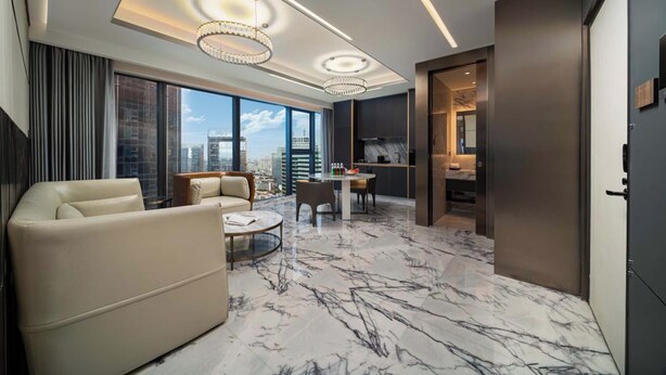 A modern living room with a sofa, a coffee table, and a dining area with a table and chairs. - Yashan Tianlai S High-Rise Hotel (Chengdu)