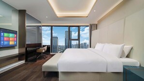A modern hotel room with a large bed, a desk, and a TV displaying hotel amenities. - Yashan Tianlai S High-Rise Hotel (Chengdu)