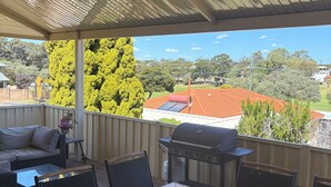 An outdoor patio with a table and chairs, a grill, and a view of the neighborhood. - Parkview house in Hillarys. Near shops and 5 minutes to the beach (Hillarys)