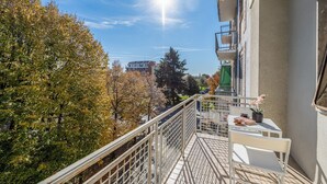 A balcony with a metal railing, a white table, and a chair. - Bright Modern and Cozy Two-room Apartment - Convenient Parking & Fast Wi-Fi (Vercelli)