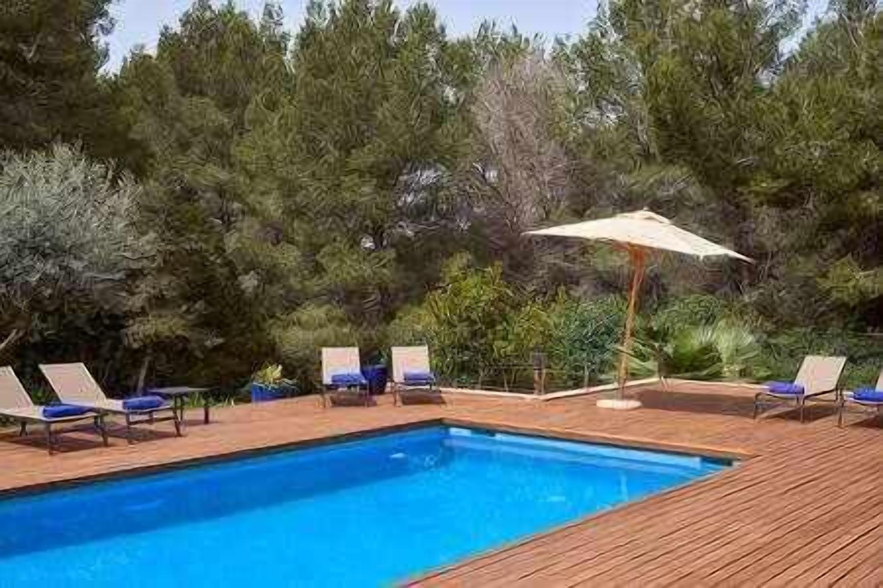 Une piscine avec une terrasse en bois et des chaises longues.