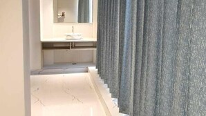 A hallway with a marble floor, a mirror, and a sink. - FRACSPACE PRIVATE LIMITED (Hyderabad)