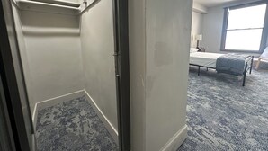 Ein Hotelzimmer mit Bett, Stuhl, Fenster und Tür.