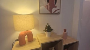 Ein Nachttisch mit einer Lampe, einem kleinen Topfpflanzen und einer Dekoration.