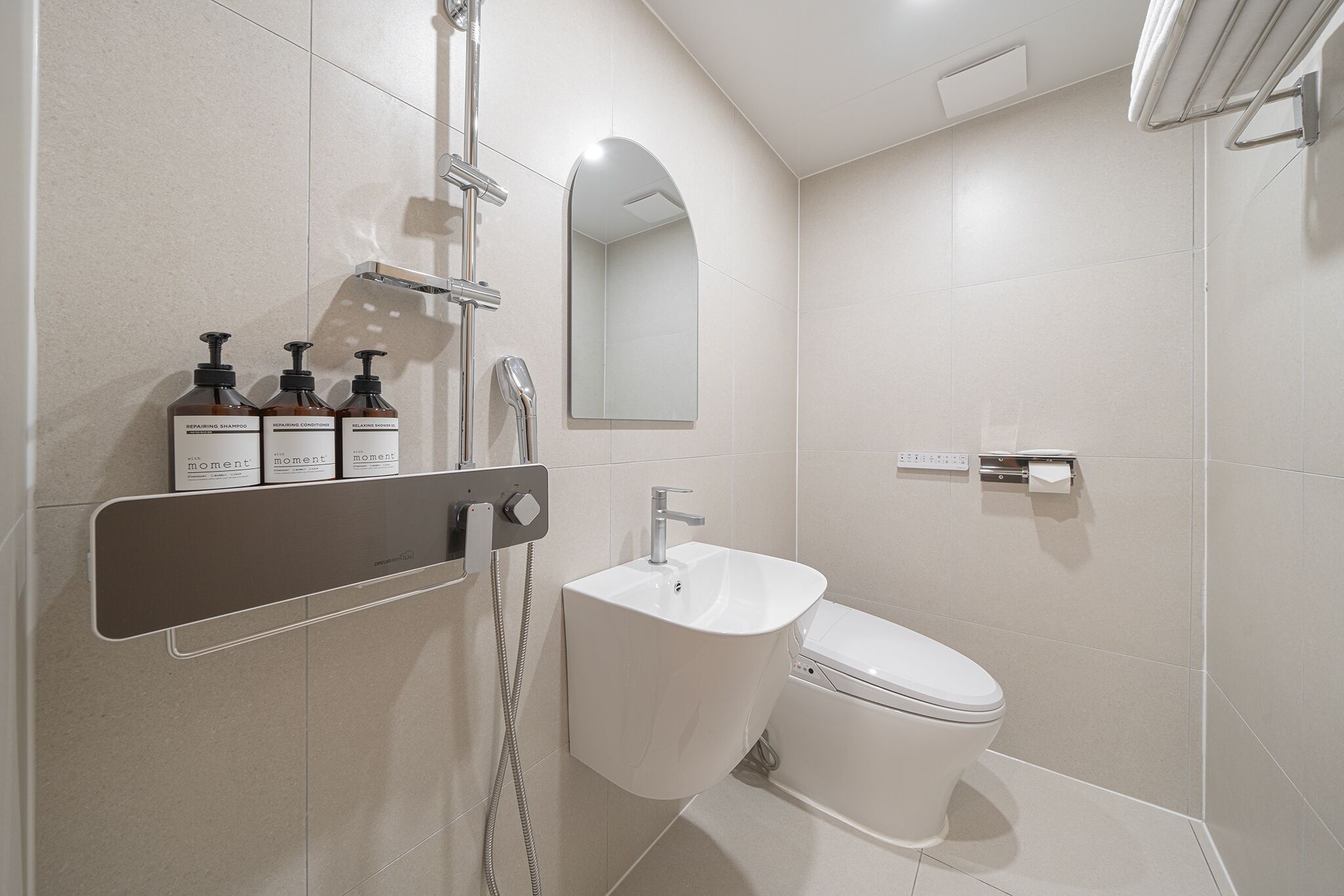A modern bathroom with a shower, toilet, and a vanity with toiletries.