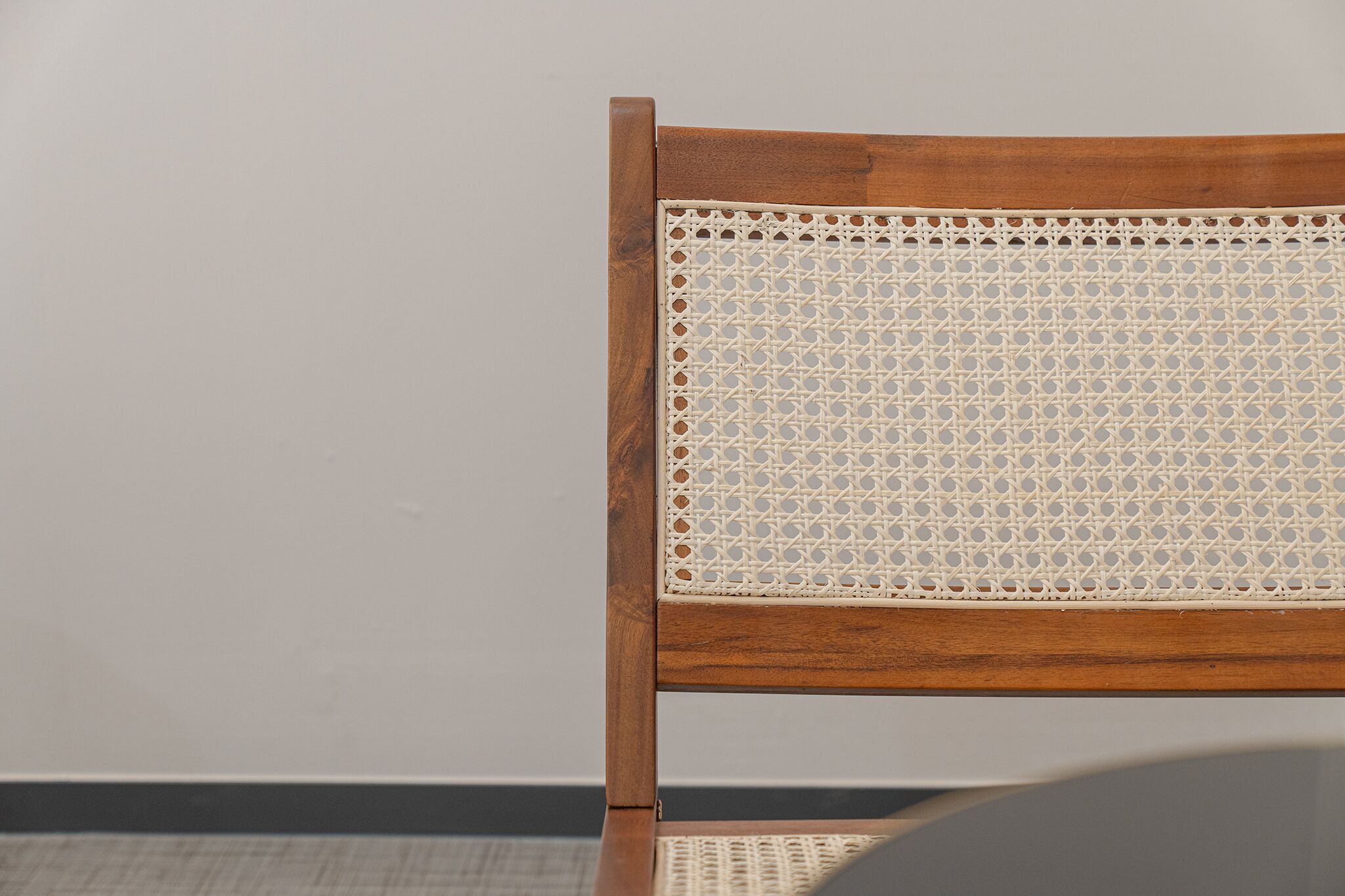 Une chaise en bois avec un dossier en osier tressé.