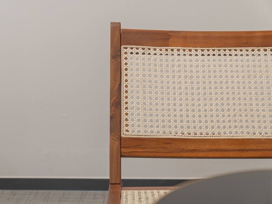 Une chaise en bois avec un dossier en osier tressé.