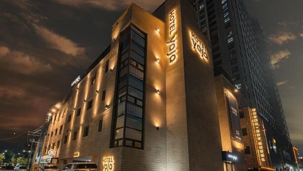 Un hotel de diseño moderno, con ventanas amplias y señalización iluminada.