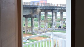 A balcony with a view of a bridge and road. - Cloud9 Airport Hotel (Aluva)