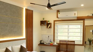 A modern hotel room with a large bed, a desk, a chair, and a window. - Cloud9 Airport Hotel (Aluva)