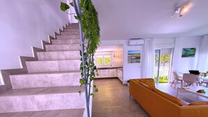 A modern interior with a staircase, a yellow sofa, and a dining area. - Villa  Red Princess - Private Heated Pool (Golf Del Sur)