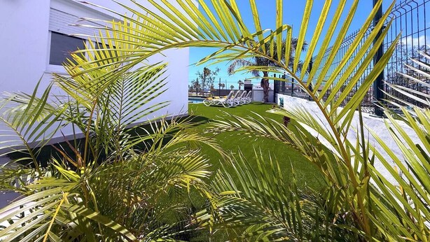A modern building with a pool area, surrounded by palm trees. - Villa  Red Princess - Private Heated Pool (Golf Del Sur)