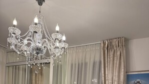 Una camera da letto con uno specchio grande, un lampadario e un letto.
