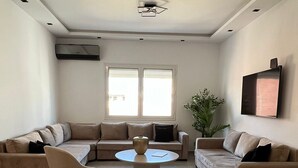 A modern living room with two beige sofas, a round coffee table, and a single armchair. - New York meets Hergla! Fantastic modern vacation apartment near the beach (Hergla)