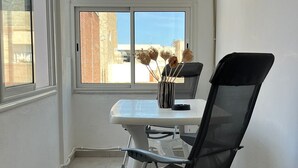 A modern room with a white table, a black office chair, and a window with a view of buildings. - New York meets Hergla! Fantastic modern vacation apartment near the beach (Hergla)
