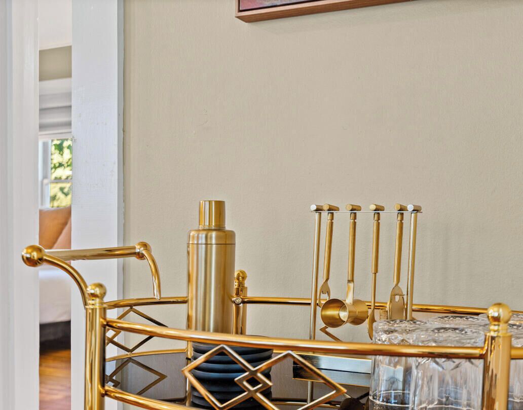 A gold-framed side table with a crystal glass holder and a decorative metal stand.