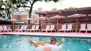 A pool area with lounge chairs and umbrellas. - Pet-Friendly East Austin Home w Free Parking & Grill│Walk to 6th & Rainey (Austin)
