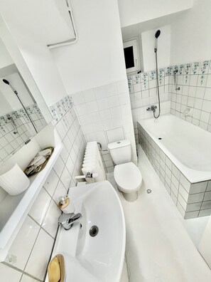 Ein modernes Badezimmer mit einer freistehenden Badewanne, einem Waschbecken, einer Toilette und einer Dusche.