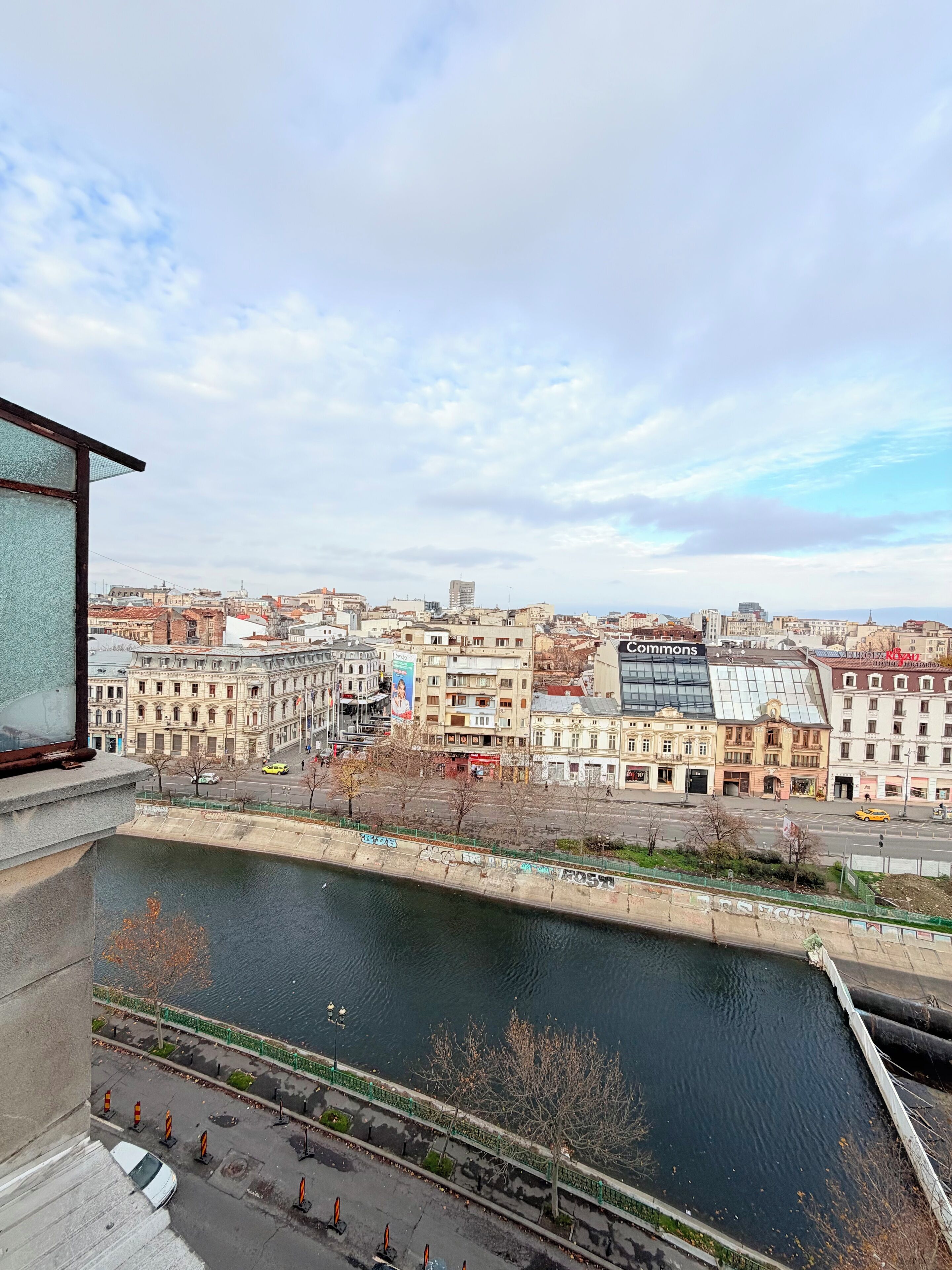 A cityscape with a river, buildings, and a bridge.