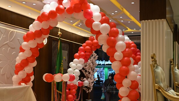 A hotel lobby with a red and white balloon archway, a reception desk, and a statue. - Masar Almisk Hotel (Makkah)