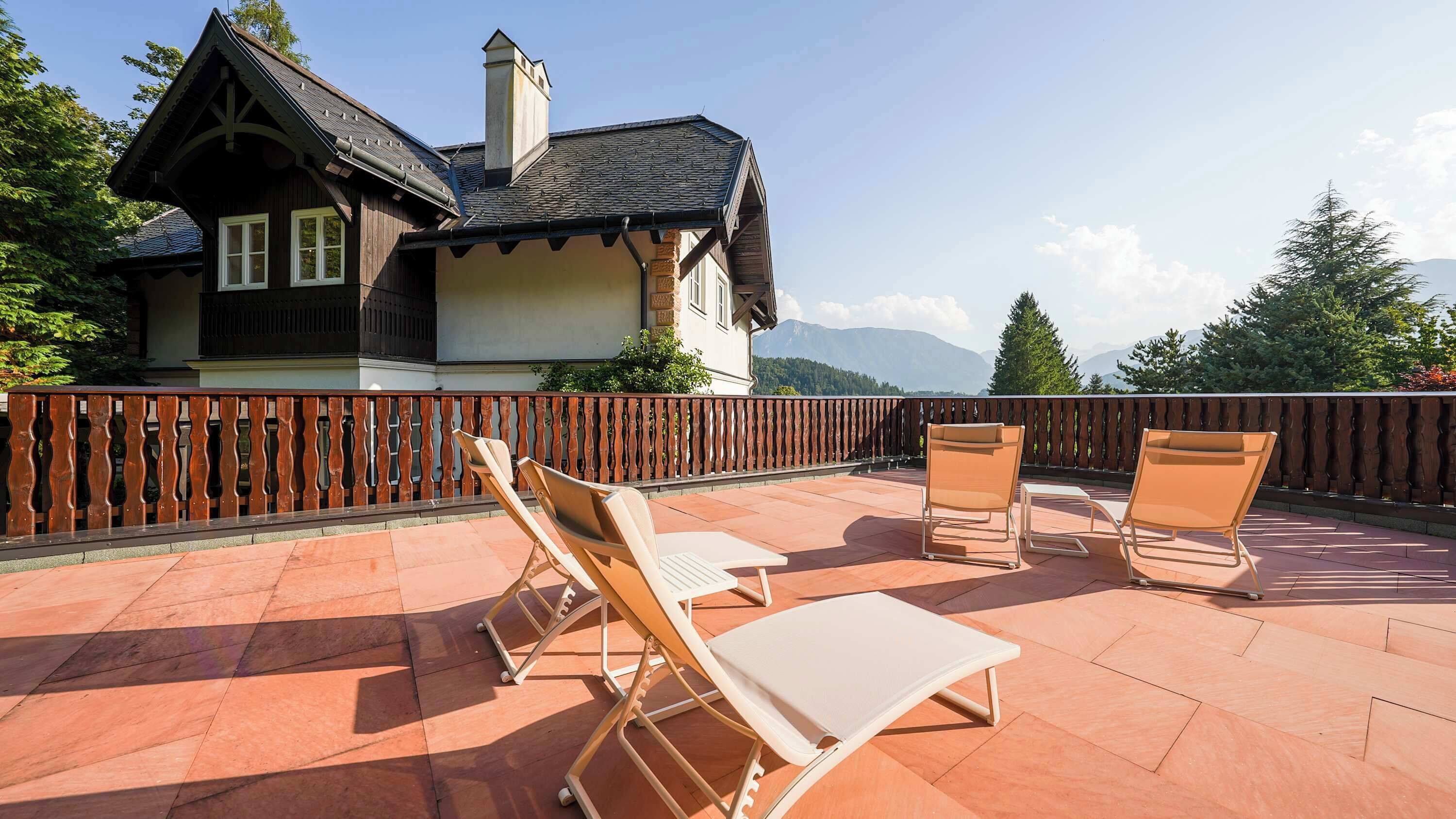 Une terrasse avec des chaises longues et une vue sur la montagne.