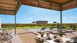 An outdoor dining area with a view of a pool and a house in the background. - Beautiful brand new villa with pool - DiCasaInSicilia (Menfi)