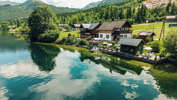 A lakeside property with multiple buildings, a dock, and a well-maintained garden. - Apartment Narzisse | Lakefront | Kitchen | Parking (Gößl)