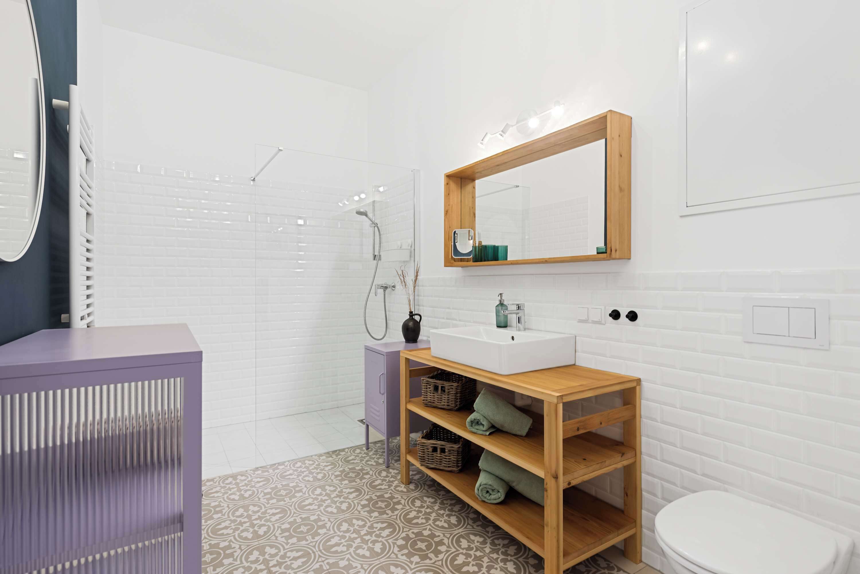 Une salle de bain moderne avec un lavabo blanc, un meuble-lavabo en bois et un espace douche.