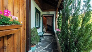 Une façade en bois et un chemin de pierre menant à une porte portant le numéro « 37 ».