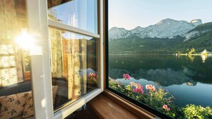 Une pièce dotée d’une grande fenêtre donnant sur un lac et des montagnes.