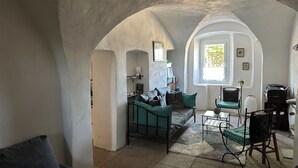 Ein gemütliches Wohnzimmer mit einer Couch, Sesseln, einem Couchtisch und einem Fenster mit Blick.