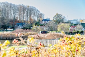 A riverside view with a wooden fence, a gazebo, and a sign for a restaurant. - KüstenGlück Langbaligau - Where the sea touches the heart. (Langballigau)