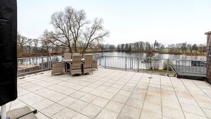 A patio with outdoor furniture, a view of a lake, and a metal railing. - Holiday Home 'Pension Seeblick' with Lake View, Private Garden and Wi-Fi (Holzappel)
