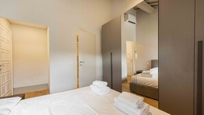 Ein Hotelzimmer mit Bett, Kleiderschrank und Spiegel.
