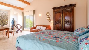 A bedroom with a large bed, a wooden wardrobe, a dining table with chairs, and a view of the outdoors. - “Jamin” Room with Private Terrace, Wi-Fi, and Air Conditioning (Fontarèches)