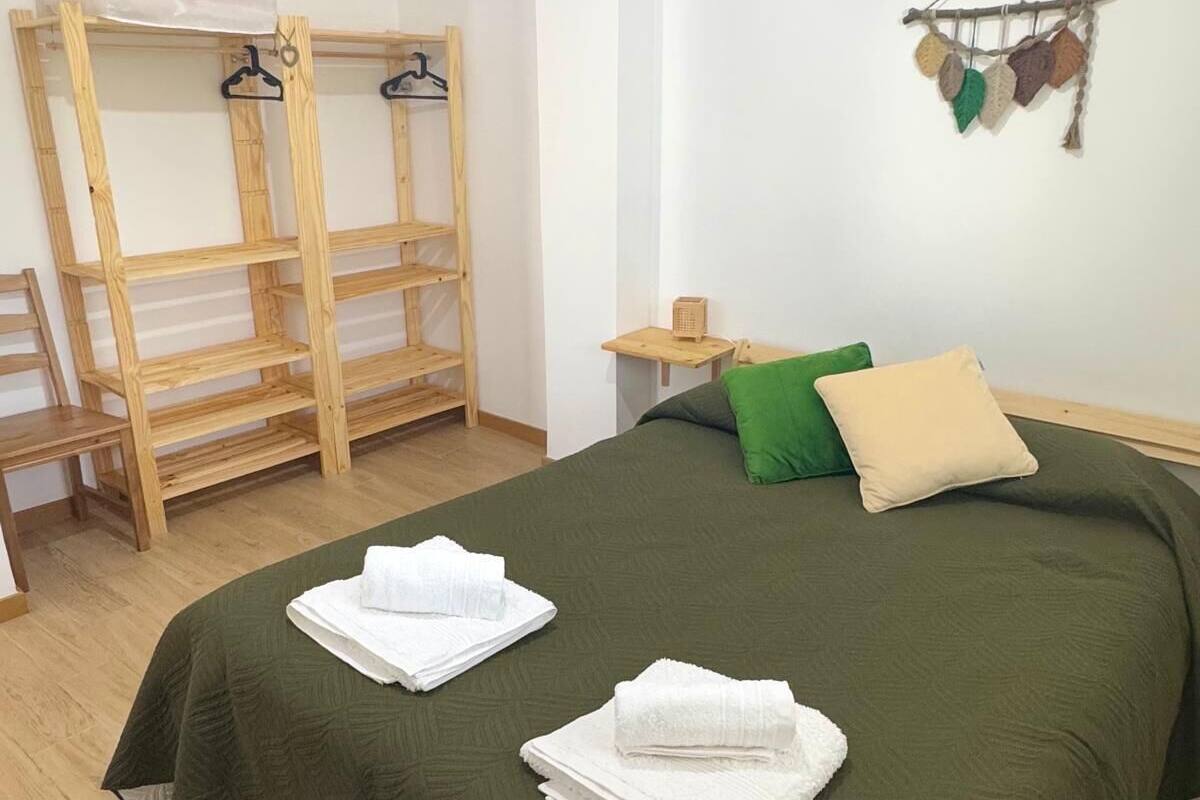 A bedroom with a bunk bed, a bedside table, a lamp, and a wall decoration.