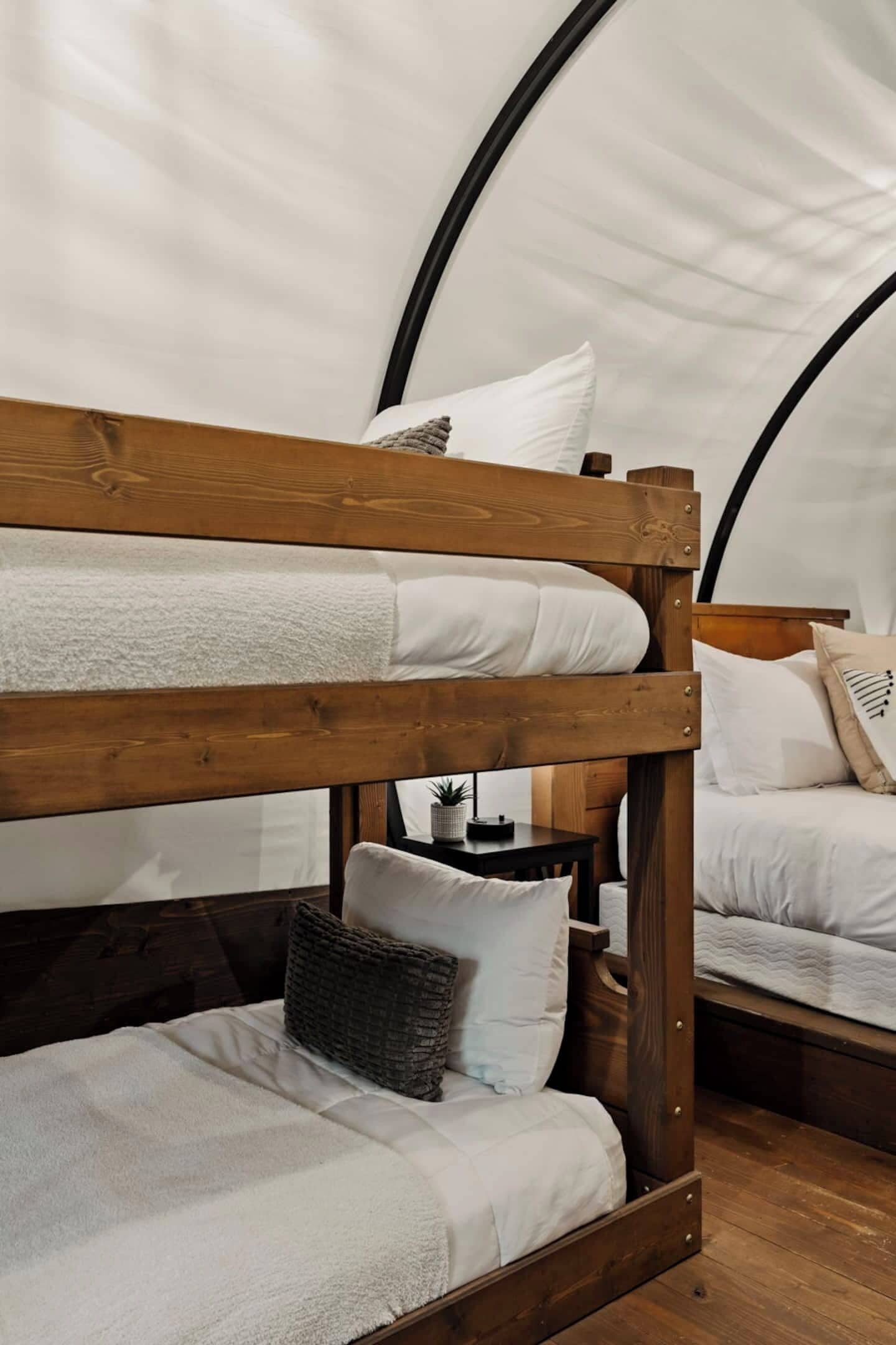 A bunk bed with white bedding and a woven basket.