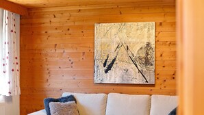 Habitació amb parets de fusta, un sofà i un quadre.