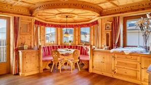 A wooden cabin interior with a dining area, wooden cabinets, and large windows. - Holiday Home 'Haus Hart Im Zillertal 6 People' with Mountain View, Terrace & Wi-Fi (Hart im Zillertal)