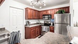 A modern kitchen with wooden cabinets, stainless steel appliances, and a granite countertop. - Cordillera Condo: Pools, Hot Tubs & Racquetball | Patio Retreat (Phoenix)