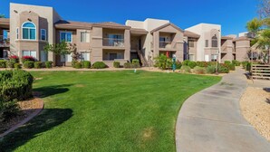 A residential building with multiple balconies, a well-maintained lawn, and a clear sky. - Cordillera Condo: Pools, Hot Tubs & Racquetball | Patio Retreat (Phoenix)