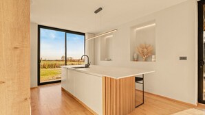 Una cucina moderna con una grande isola, una finestra vista vigneto e un design minimalista.