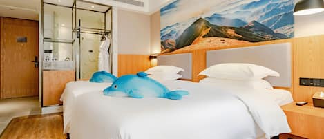 A hotel room with a bed, a large mountain landscape mural, a wooden headboard, and a wooden floor.
