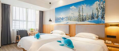 A hotel room with two beds, a large window with curtains, a painting of a snowy landscape, a desk with a chair, and a blue stuffed animal on one bed.
