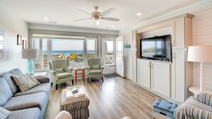 A spacious living room with a large TV, comfortable seating, and a view of the ocean. - Stay at Bunker Hill, a spacious 4-bedroom oceanfront house in charming Topsail Beach! (Topsail Beach)