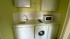 A compact kitchen with a sink, microwave, and washing machine. - Apartment near the beach with balcony for 4 people (Argelès-sur-Mer)